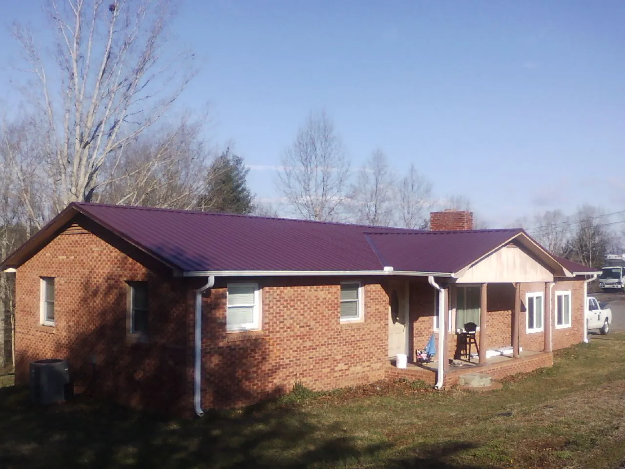 Burgundy metal roof on a brick ranch home with a new addition in Richfield